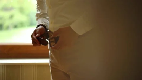 Low close-up of groom fastens his trouser belt Stock Footage 204942012