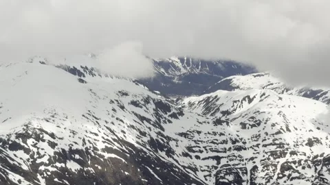 Low cloud spills across snow-streaked Coast Mountain crests in soft light Stock Footage 336218965