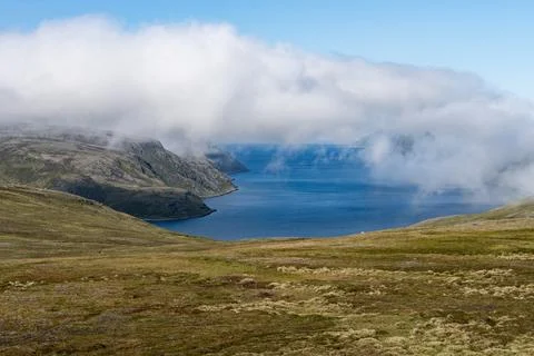 Low clouds above mossy mountains and ocean in Norway Stock Photos