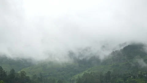 Low clouds and fog rolling over green mountain hills, misty landscape Stock Footage 330882606