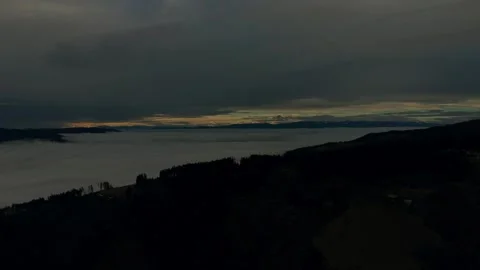 Low clouds covering forested mountain valley Stock Footage 328494202