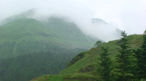 Low clouds dancing on top of green treeless mountain Stock Footage 39988001