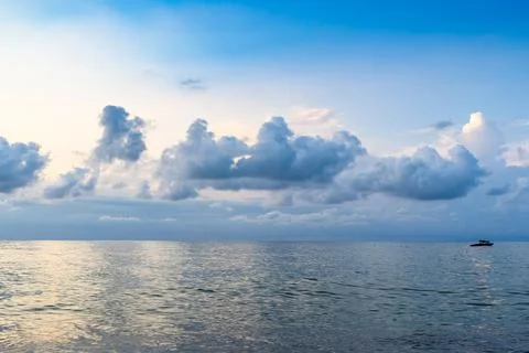 Low clouds in dark blue sky over sea water at dusk Stock Photos