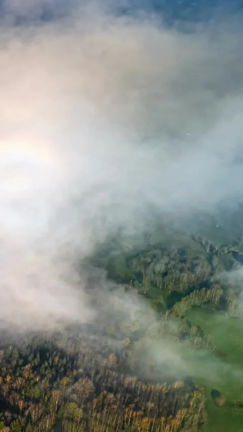 Low clouds drift over patchwork farmland, aerial vertical timelapse Stock Footage 328359047