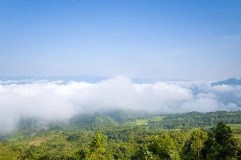 Low clouds drifting over green valley hills Stock Photos