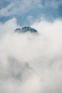 Low clouds engulfing stone pillar in Tianzi mountains in Zhangjiajie Stock Photos
