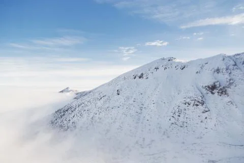 Low clouds envelops the snowy mountain peak in the Tatras Stock Photos
