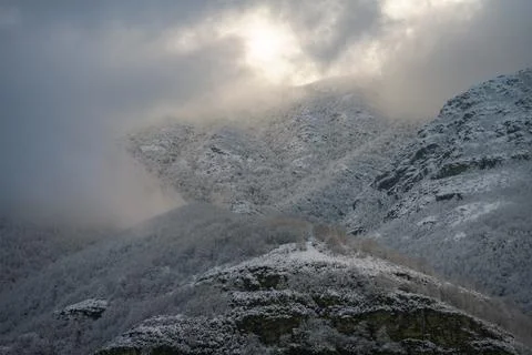 Low clouds interact with the snowy mountains Stock Photos