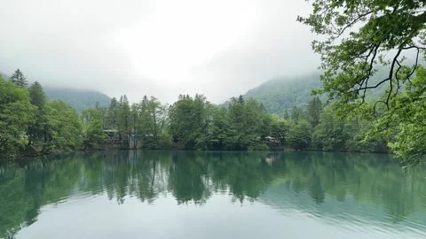 Low clouds in the mountains above the blue lake Stock Footage 277183803
