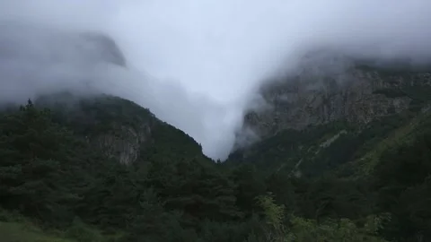 Low clouds in the mountains. Fog movement on high cliffs. Stock Footage 158459508