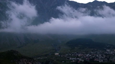 Low clouds moving above Kazbegi village in Caucasus Mountains, Evening Summer Vídeo Stock 254802951