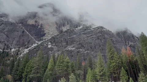 Low clouds over granite cliffs and pine forest in winter Stock Footage 347988488