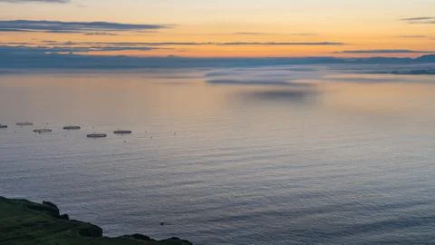 Low clouds over sea during sunrise in Scotland. Fish aquaculture farming Stock Photos