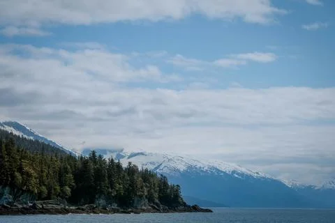 Low clouds over snow capped mountains and sea in Alaska Stock Photos