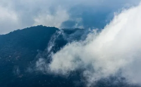 Low clouds over valley, view from the mountains. Low clouds. Stock Photos
