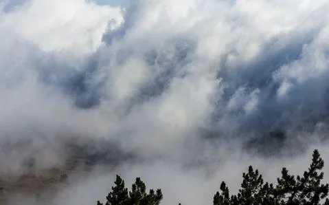 Low clouds over valley, view from the mountains. Low clouds. Stock Photos