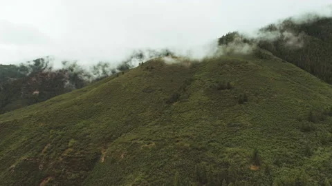 Low clouds rolling over a green mountain ridge aerial Stock-Footage 154878785