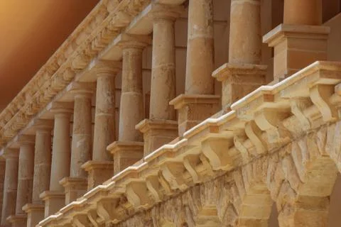 Low columns of orange limestone stone, elements of external architecture. Stockfoto's