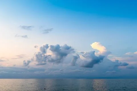 Low cumuli cloud in dark blue sky in over calm sea Fotos Stock