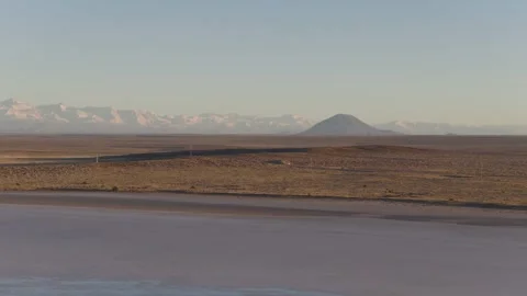 Low daisy cutter drone over salt flats and dirt. Tracking towards Diamante Stock Footage 312373390