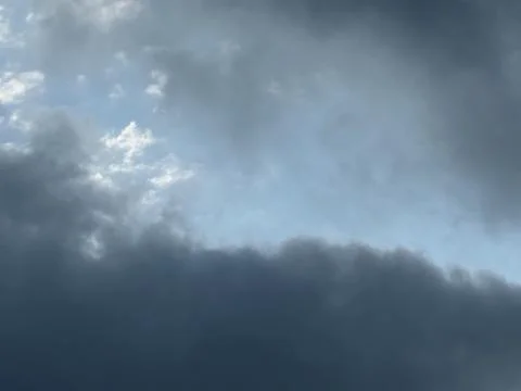 Low Dark Storm Cloud Beneath Pale Sky Фото