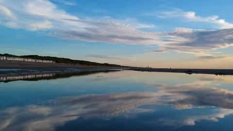 Low down drone shot skimming over beach puddle Stock Footage 122449464