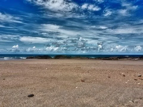 Low down drone view of beach and powerful clouds Stock Photos