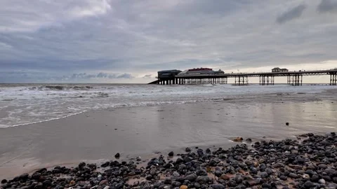 Low down view across the beach as the tide rolls in Stock Footage 314221292
