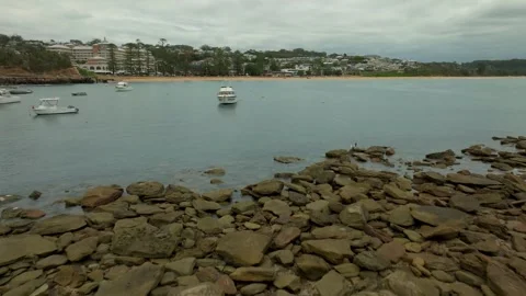Low Drone Aerial Movement Over Rocks Oceans and Boats Towards Terrigal Video stock 308510878
