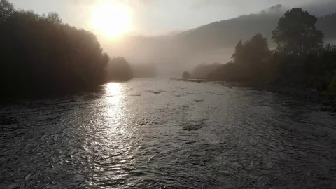 Low drone altitude flight over fresh fast mountain river with village at sunny s Video stock 117464307
