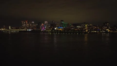 Low drone flight over dark St. Lawrence river toward Montreal skyline and Vidéo 347369015