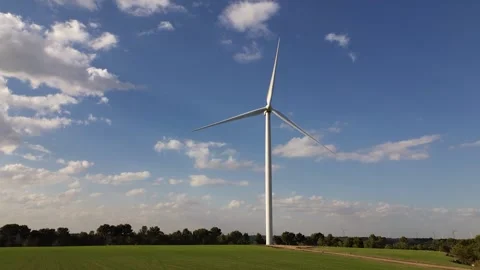 Low Drone Flight Over Green Cereal Field Moving Away from Wind Turbine Stock Footage 331118344