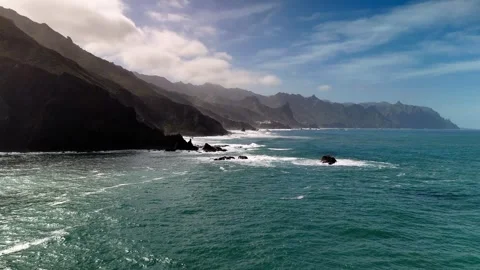 Low drone flight over ocean waves near Roque de las Bodegas, Tenerife Stock Footage 336453207