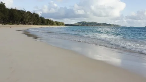 Low drone flight over sandy beach and sea waves along the coast of Hawaii Stock Footage 126604848
