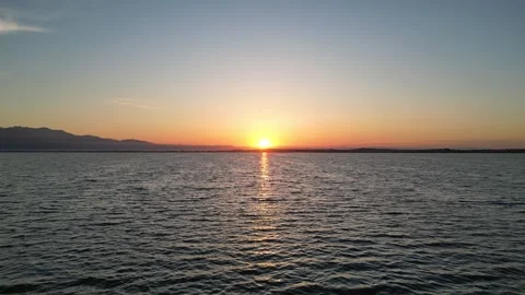 Low Drone Flight Toward Red Sunrise Above the Aegean Sea with Flying Bird, G Stock Footage 340556477