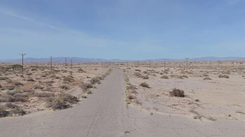 Low Drone Flyover of Abandoned Street with Power Lines in Salton City Видео 332683045