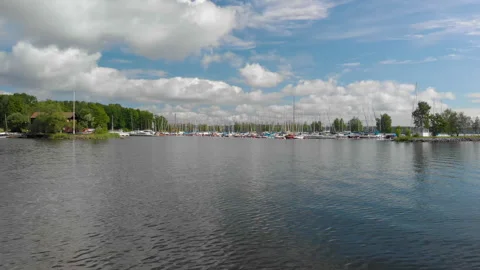 Low drone footage parallel with a harbor with sail boats. Stock Footage 284231911