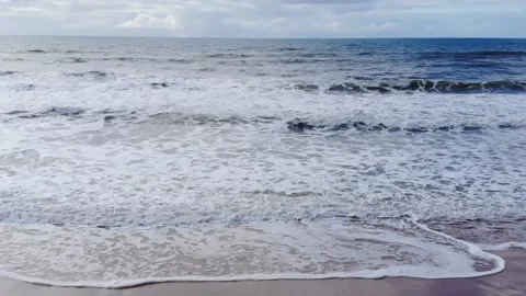 Low drone image of waves breaking at the shore Vídeo Stock 131928251