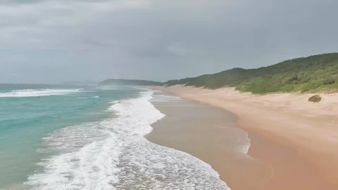 Low drone over beach, waves crashing 2 Stock Footage 304266296