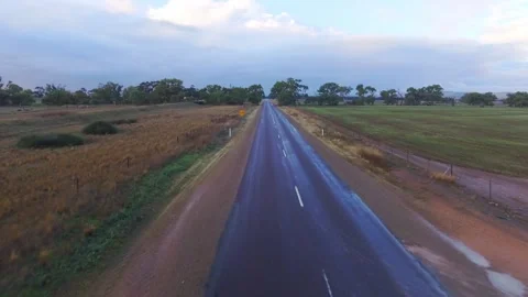Low Drone Shot Flying Along Wet Road in Australian Outback with Floodway Sign Stock Footage 331277107
