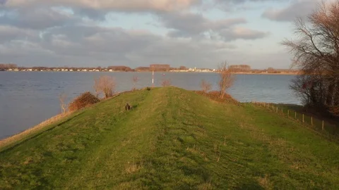 Low drone shot flying over a dyke next to the Canal through Walcheren. Stock Footage 128965666