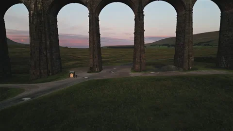 Low Drone Shot Flying Through Ribblehead Viaduct Arch at Sunrise Video stock 248418927