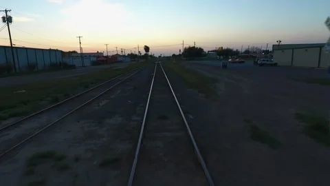 Low Drone Shot Following Parallel Railroad Tracks in Small Texas Town at Sun Stock-Footage 308189410