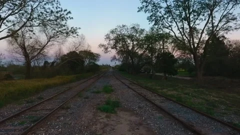Low Drone Shot Following Parallel Railroad Tracks in Texas Town at Dusk Stock Footage 308191226