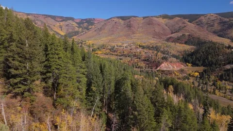 Low drone shot over hill to reveal Aspen mountain in autumn Stock Footage 252568729