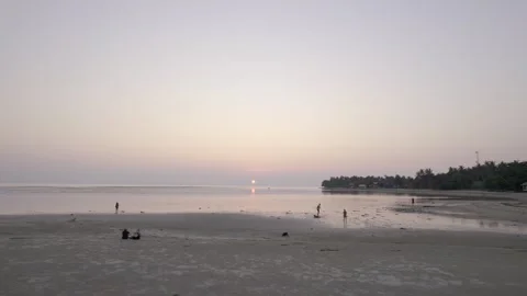 Low drone shot of Sunset, close to water with people on beach, evening Stock Footage 277104442