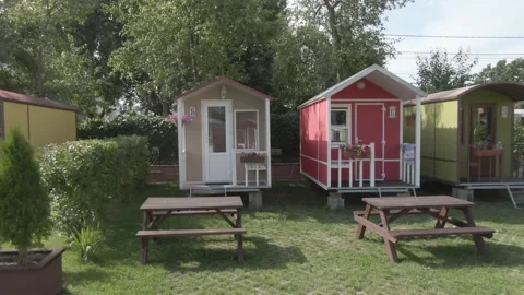 Low drone side flight through camping cabins 動画素材 333954804