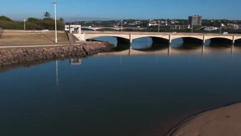 Low drone view of the Umgeni River from the sea and over the M4 bridge Stock Footage 240295580