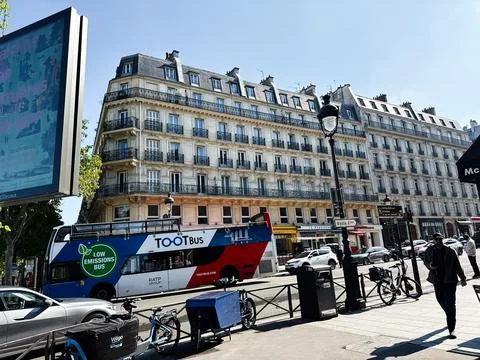 Low emissions TootBus double decker passing Haussmann buildings on a sunny .. Stock Photos