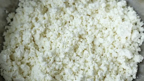 Low-fat, useful from cow's milk, white crumbly curd is poured from above into an Stock Footage 103568423